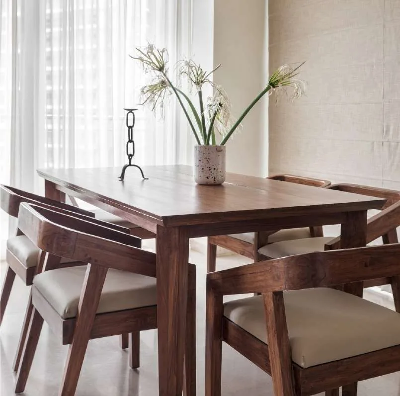 Wooden dining table with a vase of white lilies